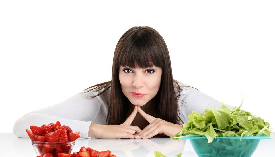 γυναίκα στο τραπέζι με βότανα και φράουλες